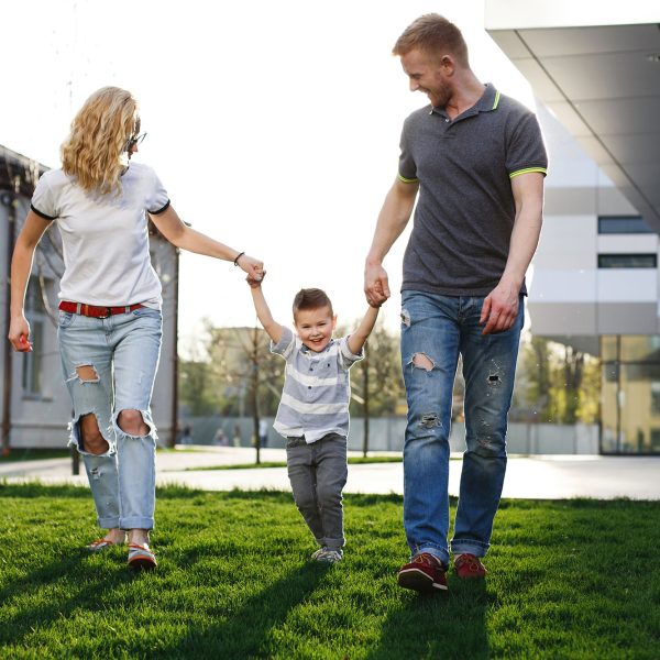 Mom and dad whirl their son and have fun walking outside